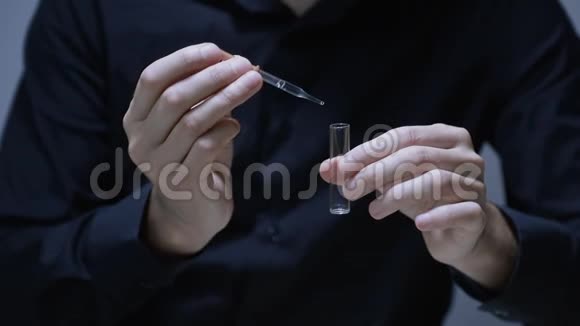 人手中拿着移液管和试管将三滴药物滴入试管中视频的预览图