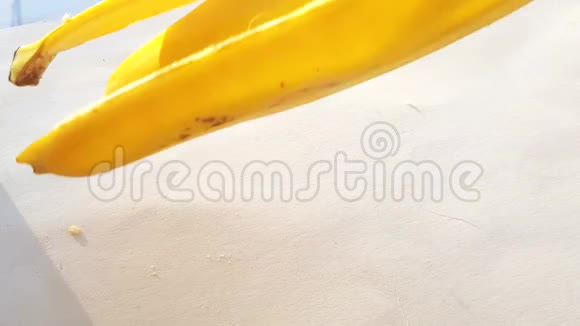 桌子上白色背景上的香蕉皮阳光明媚视频的预览图