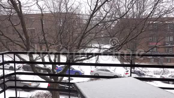 在住宅区的阳台上雪落在桌子上的景色视频的预览图