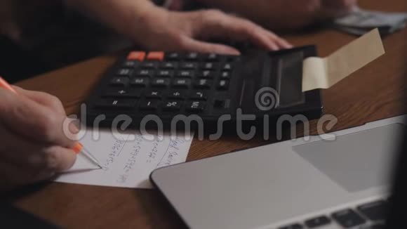 老人在计算器上清点现金和检查结果的手视频的预览图