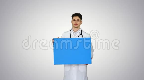微笑男医生穿着听诊器在梯度背景上拿着空白海报视频的预览图