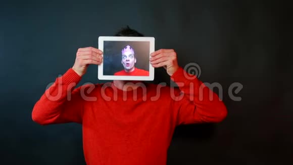 一个人手里拿着一块石碑在平板电脑屏幕上一位开朗的摄影师视频的预览图
