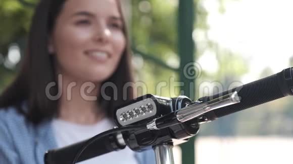 一个特写电动滑板车的正面在背景中离焦了一个微笑的女孩的脸视频的预览图