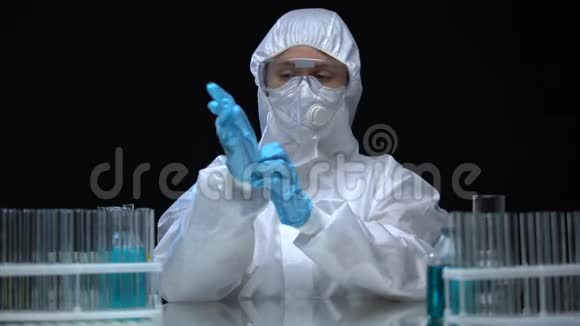 穿防护服的实验室工作人员戴橡胶手套准备有毒作业视频的预览图