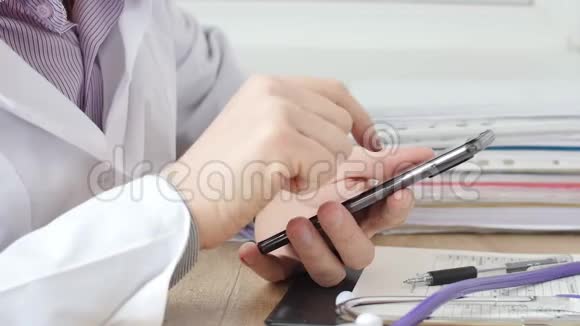 男性手中的医生在智能手机上键入短信视频的预览图
