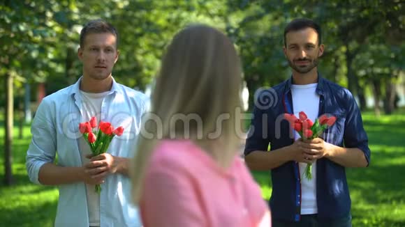兴奋的女人两个仰慕者捧着鲜花邀请她约会选择视频的预览图