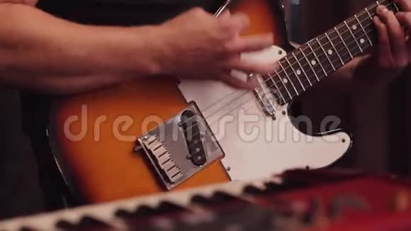 吉他手在舞台上的音乐会上弹电吉他一位带木制棕色吉他的吉他手的现场表演视频的预览图