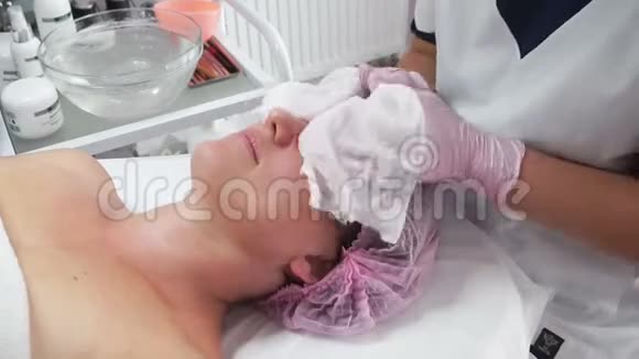 美容师用湿巾清洁成年妇女的面部视频的预览图