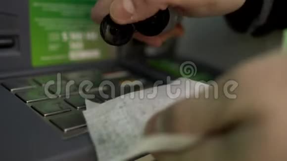 在冠状病毒流行期间男子使用洗手液防腐剂和餐巾擦拭ATM银行键盘预防视频的预览图