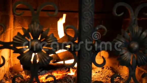 木制原木燃烧着橙色的火焰在带铁门的砖砌壁炉里发光家中温暖壁炉带视频的预览图