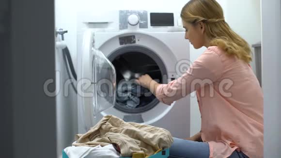 从洗衣机里拿出衣服的女人洗衣服务日常生活视频的预览图