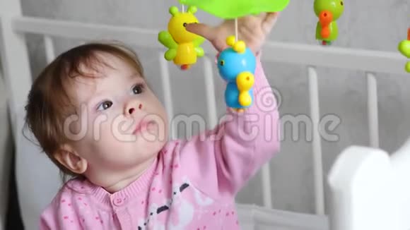 婴儿在他的婴儿床里在儿童房里玩玩具视频的预览图