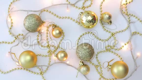 白色背景上的圣诞金色装饰和闪烁的点缀着星星的花环从上面看固定的视频的预览图