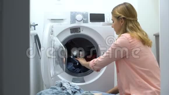 女人洗完衣服后嗅着衣服很高兴闻到肥皂粉的味道洗衣服视频的预览图