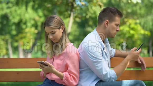 男朋友和女朋友背靠背坐在电话里男生嫉妒女孩子视频的预览图