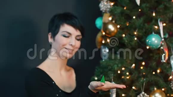 一个女人手里拿着一个小圣诞树玩具视频的预览图