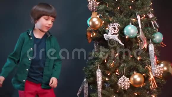 一个男孩在学校的圣诞树附近跳舞视频的预览图