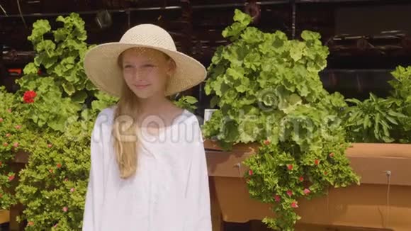 度假酒店阳光明媚的一天戴着草帽的肖像少女戴着绿帽子的微笑少女视频的预览图