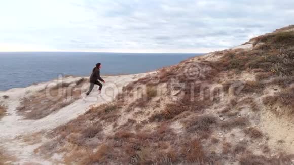 在海边的悬崖上攀爬运动女孩徒步户外训练能源的概念视频的预览图