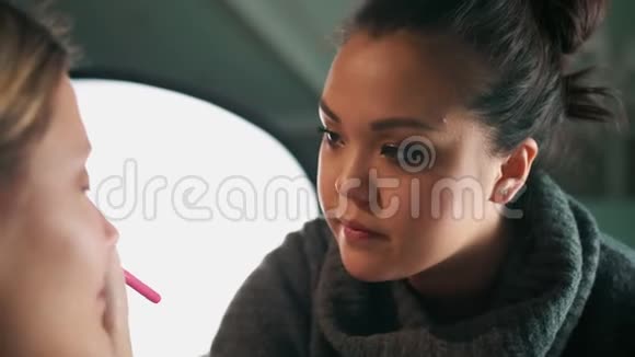 亚洲化妆艺术家化妆用画笔描绘眼睛上的阴影多种族视频反对视频的预览图