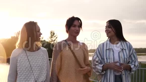 三位女性朋友在海滨散步面带微笑谈笑风生视频的预览图