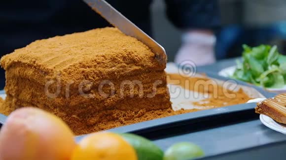 一个拿刀切自制蜂蜜蛋糕的男人视频的预览图
