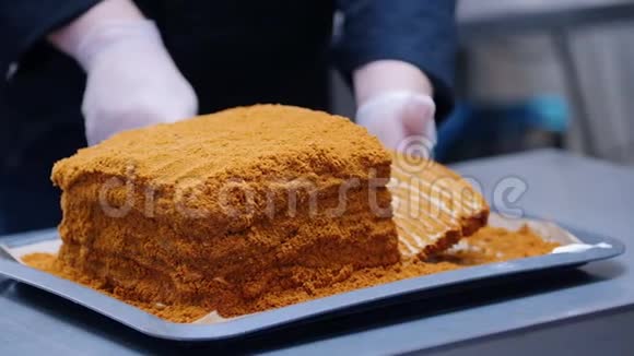 一个男人用刀切蜂蜜蛋糕准备上桌视频的预览图
