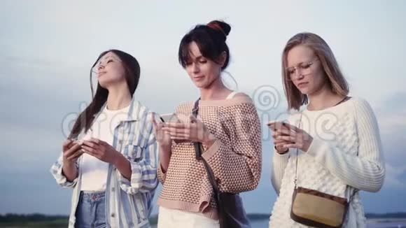 三位女士在街上用智能手机发短信视频的预览图