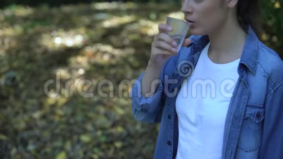 女人喝水扔掉杯子全球塑料过度消费视频的预览图