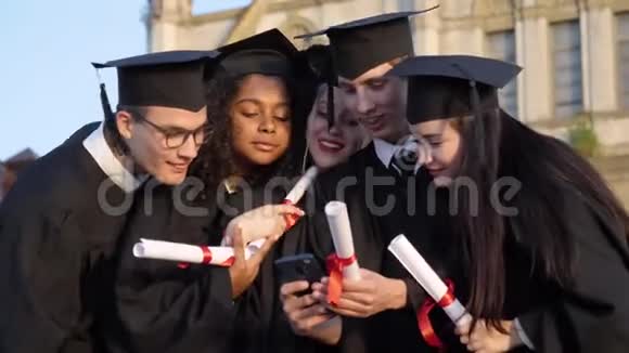 快乐的一群学生在毕业当天在手机上嘲笑什么视频的预览图