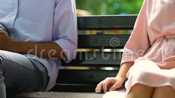 男学生触摸躺在长凳上的年轻女子的手同情和调情视频的预览图