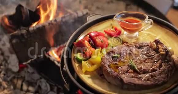 烤肉和蔬菜的大块放在盘子里多汁的牛排靠近大裸的火焰酱汁红色视频的预览图