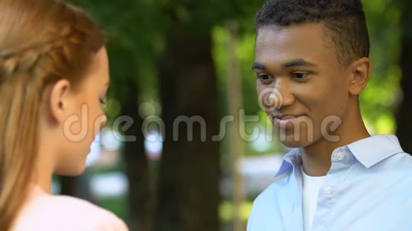 男青少年在公园给可爱的女孩送花宣布爱情神奇的时刻视频的预览图