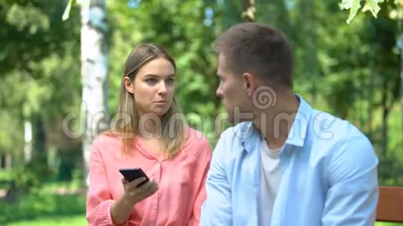 愤怒的女人对丈夫大喊大叫看着他手机上的照片嫉妒视频的预览图