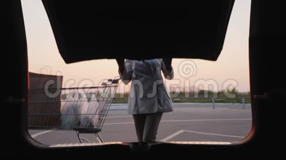 女人把购物袋放在汽车的后备箱里宽镜头拍摄视频的预览图
