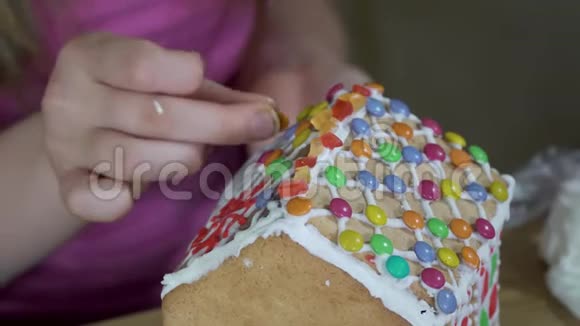 女孩装饰圣诞姜饼屋视频的预览图