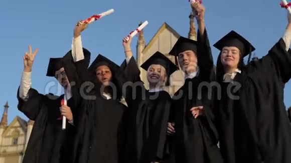 快乐的一群学生在毕业典礼上举起双臂视频的预览图