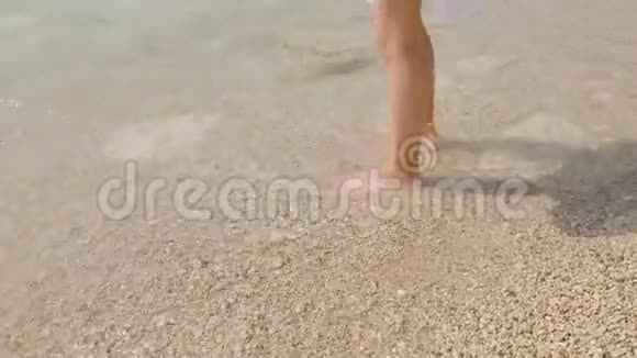 少女在鹅卵石滩上散步出海旅游女孩在晴天享受海水年轻女孩夏天视频的预览图