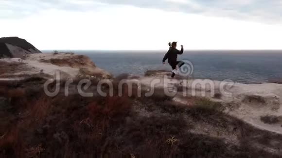 一个穿着运动服的女人在一个地方跑步的无人视野悬崖上的健康无人机视野视频的预览图