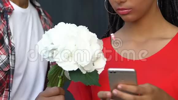 黑人少女在智能手机上聊天无视男友送花视频的预览图
