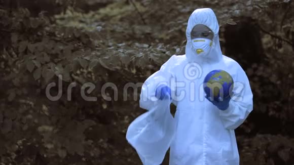 穿着防护服的女人把地球的塑料袋扔进垃圾填埋场视频的预览图