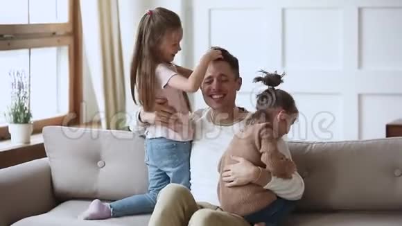 快乐的爸爸抱着可爱的小女儿玩有趣的游戏视频的预览图