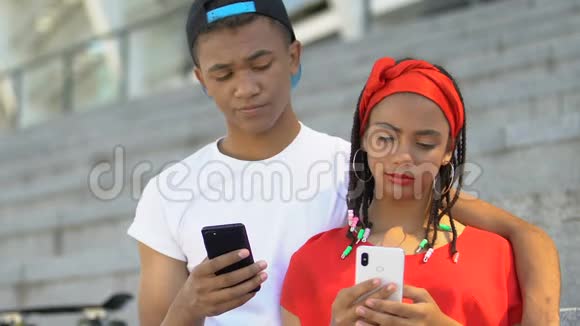 被淘汰的黑人青少年情侣聊天智能手机而不是现场交流视频的预览图