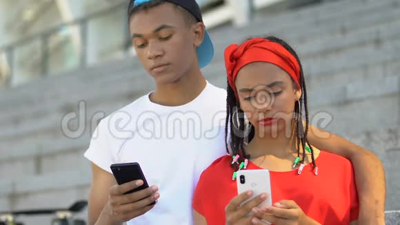 非洲裔美国青少年夫妇在智能手机上聊天缺乏沟通视频的预览图
