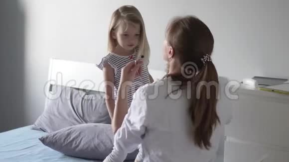 医生在医院里用听诊器听一个小女孩说话视频的预览图