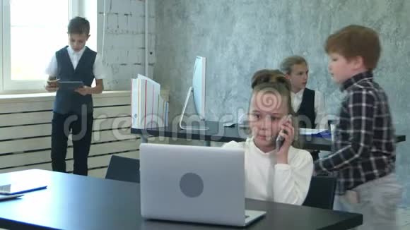 两个小孩子在现代办公室讨论和工作笔记本电脑视频的预览图