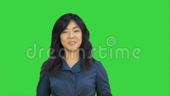 积极的亚洲女商人说话看着绿色屏幕上的摄像机Chroma键视频的预览图