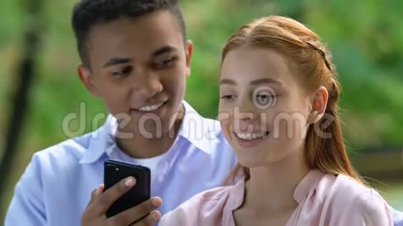 男朋友在电话里向惊讶的女孩展示惊喜社交媒体上的爱情信息视频的预览图