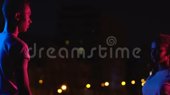 迷人的非裔美国青少年情侣在夜晚的城市灯光中拥抱爱视频的预览图