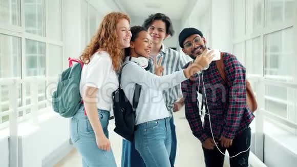 利用智能手机摆姿势在大学大厅自拍的学生小组视频的预览图